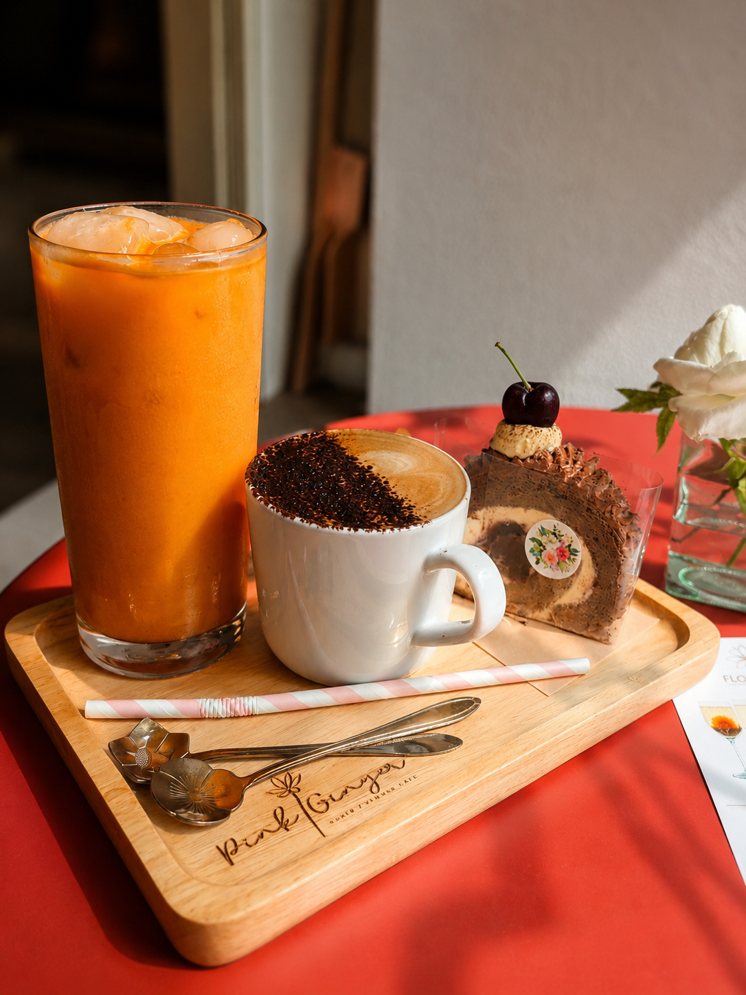 Orange drink, coffee and a chocolate cake slice on a wooden tray