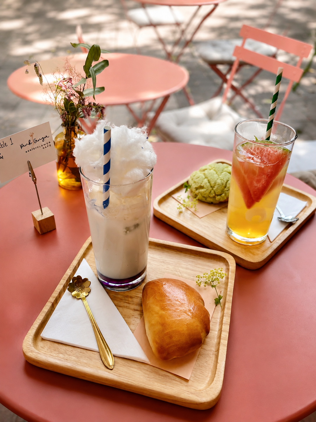 Outdoor table with drinks and a pastry at Pink Ginger Flower Cafe