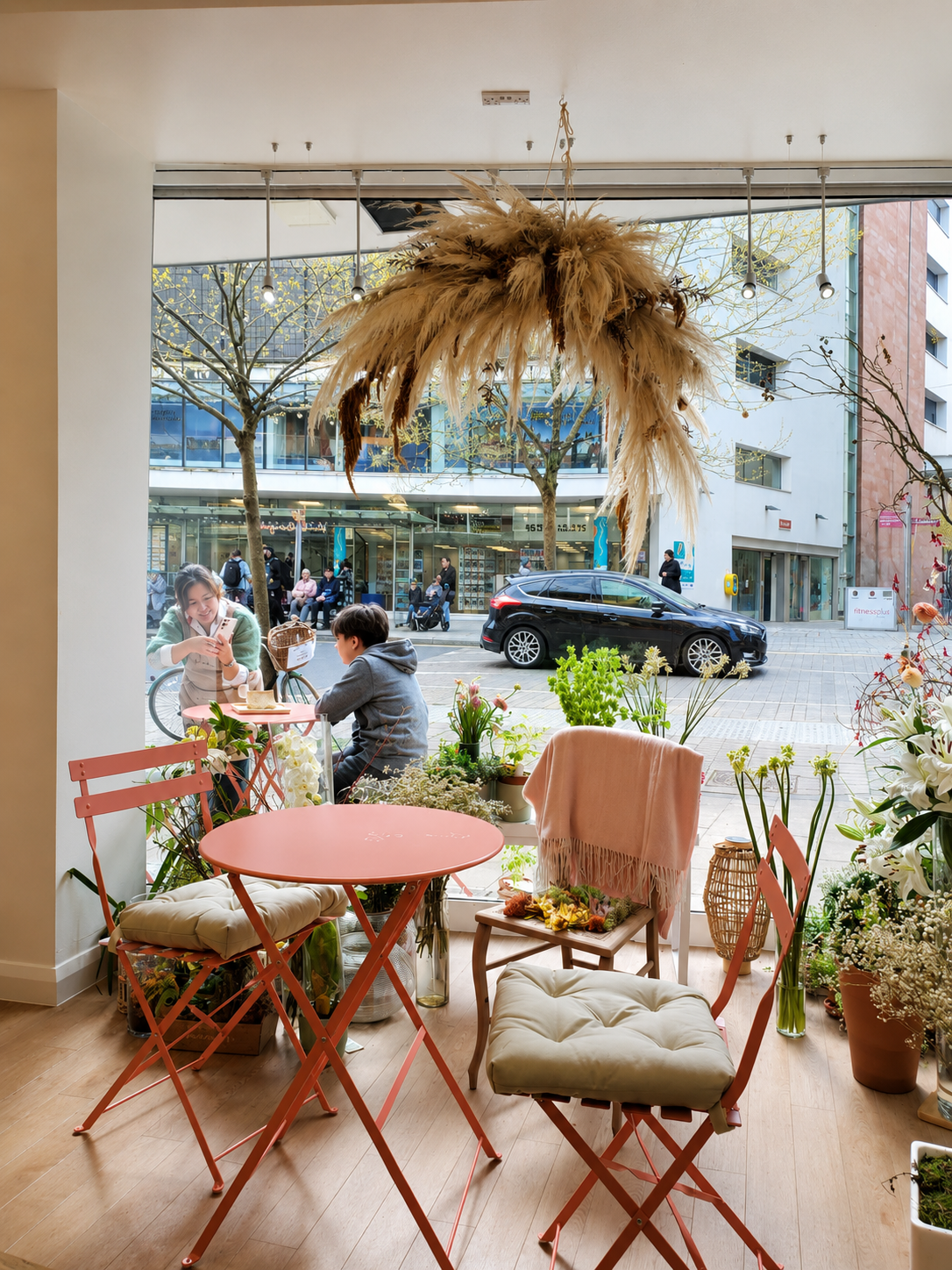 Window seating with pink tables and flowers inside Pink Ginger Flower Cafe